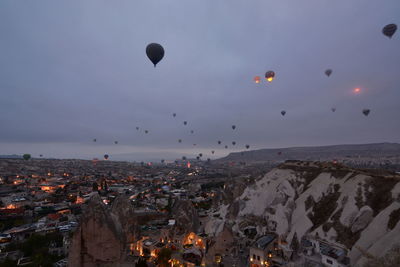 Hot air balloons flying over buildings in city