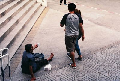 Rear view of men walking on footpath