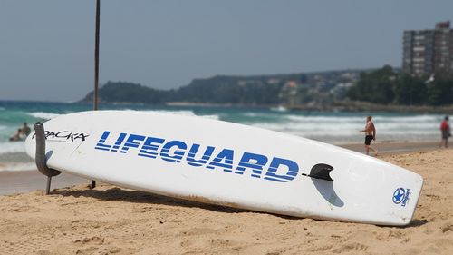 Information sign on beach against clear sky