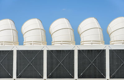 Low angle view of industry against blue sky