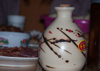 Close-up of food in plate by urn on table