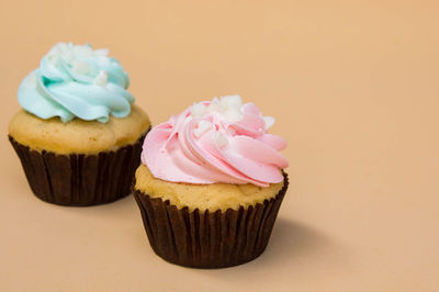 Close-up of cupcakes against colored background