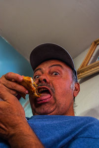 Portrait of man eating food at home