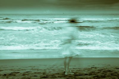 Blurred motion of person standing at beach