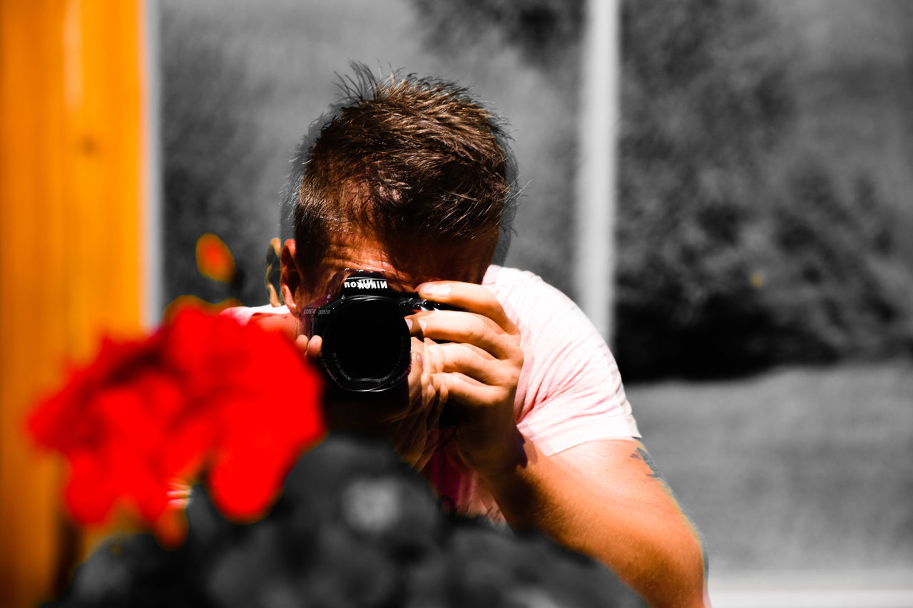 PORTRAIT OF MAN HOLDING CAMERA