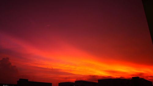Silhouette of buildings against orange sky