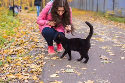 Woman with dog on leaves during autumn