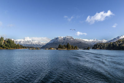 Scenic view of lake by mountains against sky