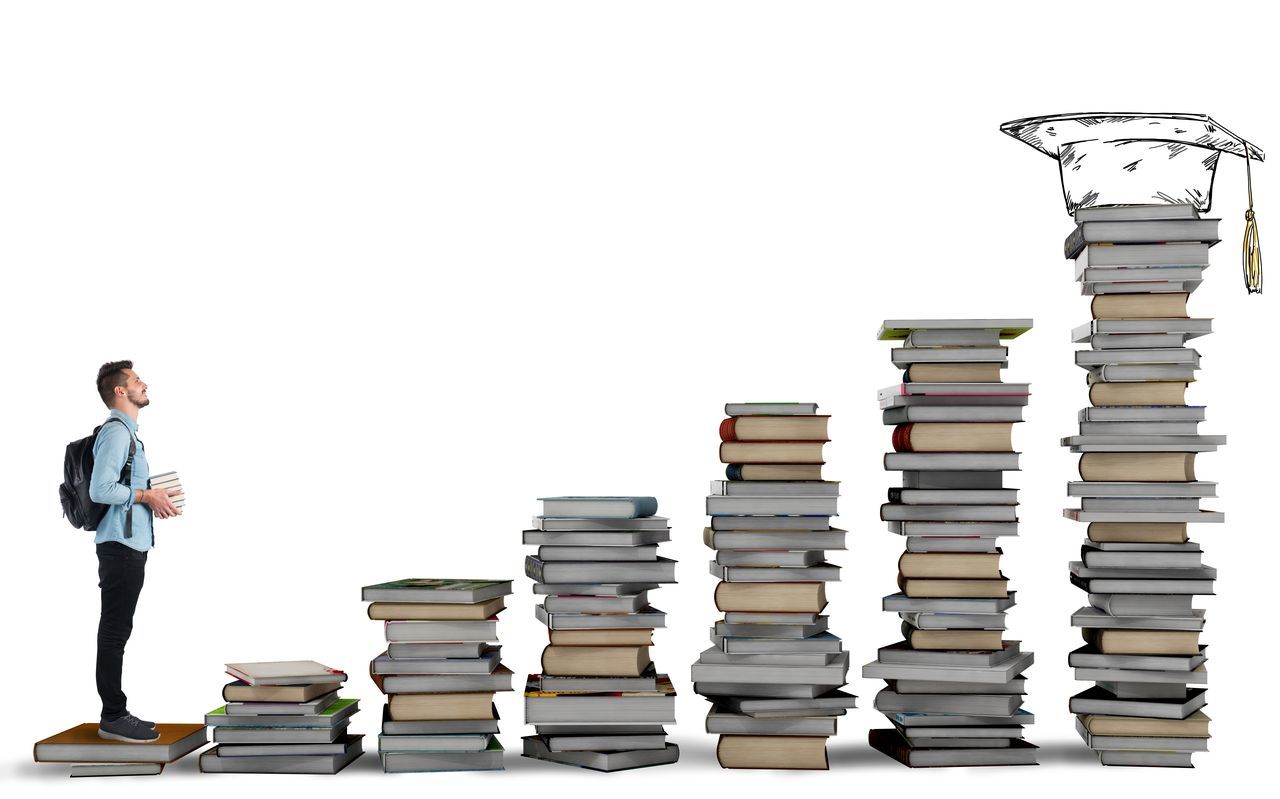 STACK OF BOOKS ON TABLE AGAINST GRAY BACKGROUND