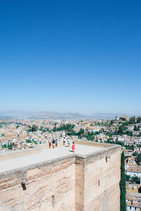 High angle view of people on building terrace against clear blue sky