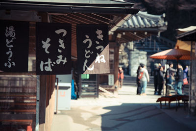 People on street amidst buildings in city