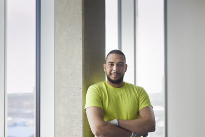 Portrait of young man looking through window