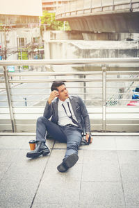 High angle view of thoughtful businessman while sitting on elevated walkway