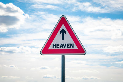 Road sign against sky