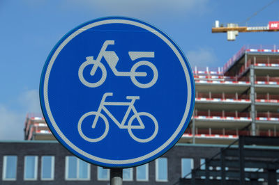 Close-up of road sign against buildings in city