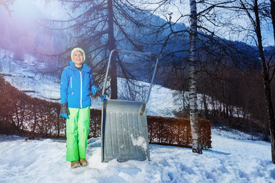 Full length of woman standing on snow covered field