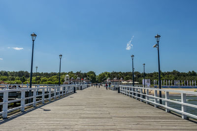 Footbridge over street against blue sky