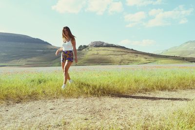 Full length rear view of man on landscape against sky