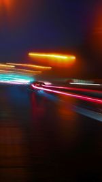 Light trails on road against sky at night