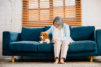 Portrait of young woman sitting on sofa at home