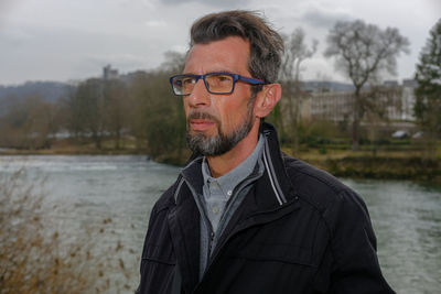 Portrait of man standing against water