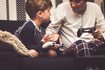 Father and son playing video game at home