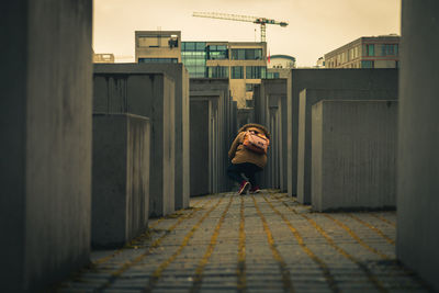 Rear view of woman standing against building