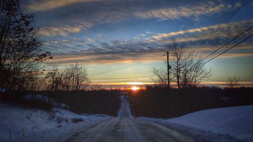 Road amidst bare trees during winter