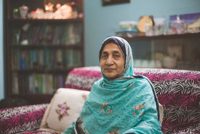 Portrait of senior woman sitting on sofa at home