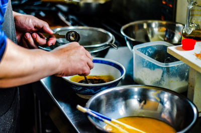 Midsection of man preparing food in kitchen