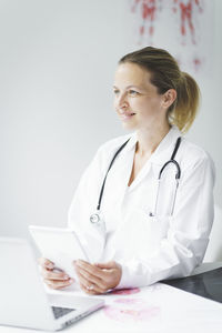 Smiling doctor with digital tablet at clinic