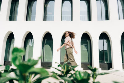 Rear view of woman standing against building