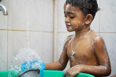 Boy taking bath in bathroom