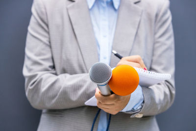 Female reporter at news conference, writing notes, holding microphone. freedom of the press concept.