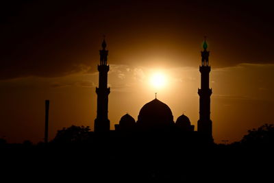 Silhouette mosque temple against sky during sunset