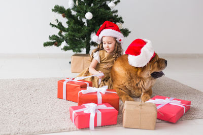 Full length of young woman in red christmas tree