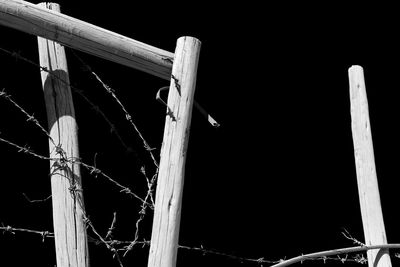 Low angle view of fence against sky at night
