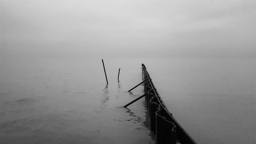 Groyne in sea during foggy weather