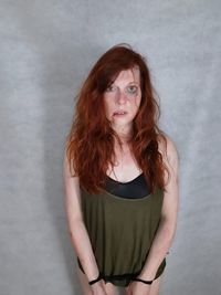 Portrait of beautiful woman standing against wall