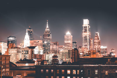 Illuminated buildings against sky at night