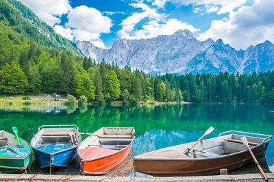 Boats moored in lake against mountains