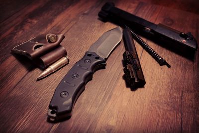 Close-up of bullets with gun on wooden table