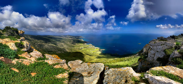 Idyllic shot of landscape and sea against sky