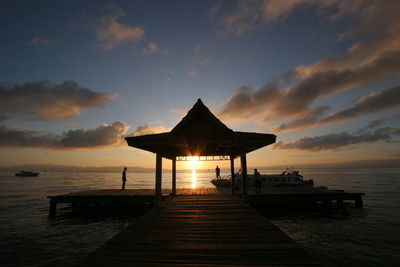 Pier over sea against sky during sunset