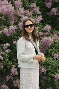 Young woman standing against plants