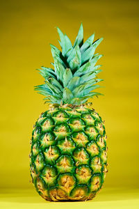 Close-up of fruit on table against yellow background