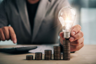 Close-up of man holding light bulb