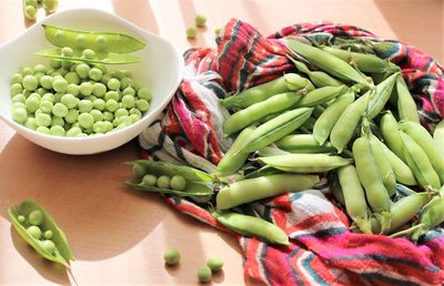 High angle view of peas being shelled on a tables