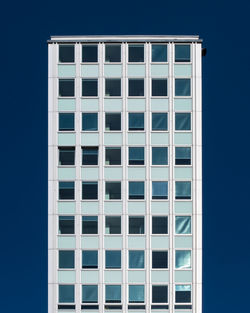 Low angle view of modern building against clear blue sky