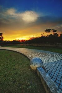 Scenic view of grass against sky during sunset